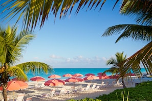 Am Strand, weißer Sandstrand, Liegestühle, Sonnenschirme