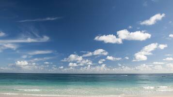 På stranden, hvit sand, strandhåndklær og massasje på stranden