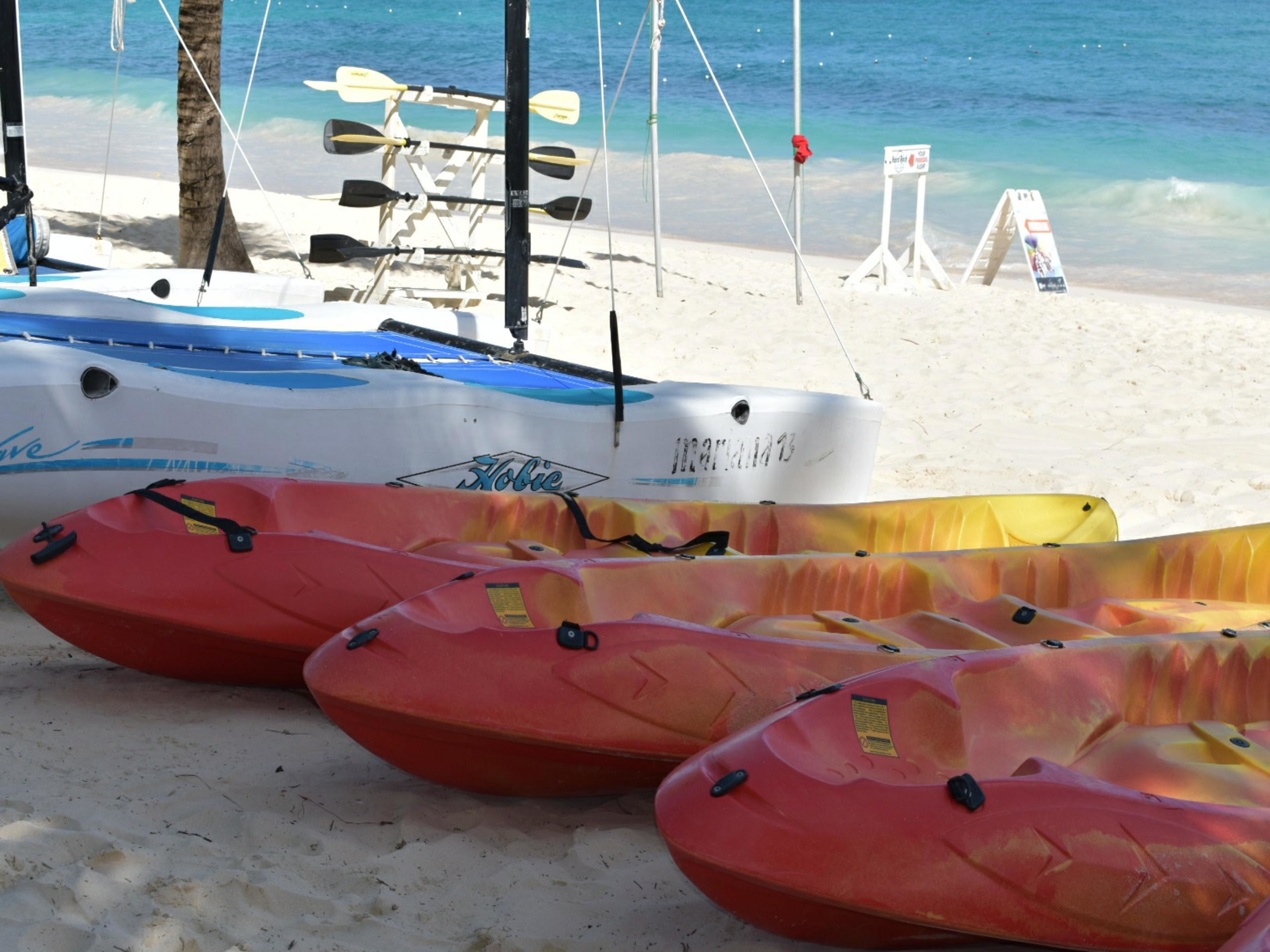 A beach with kayaks and a boat.