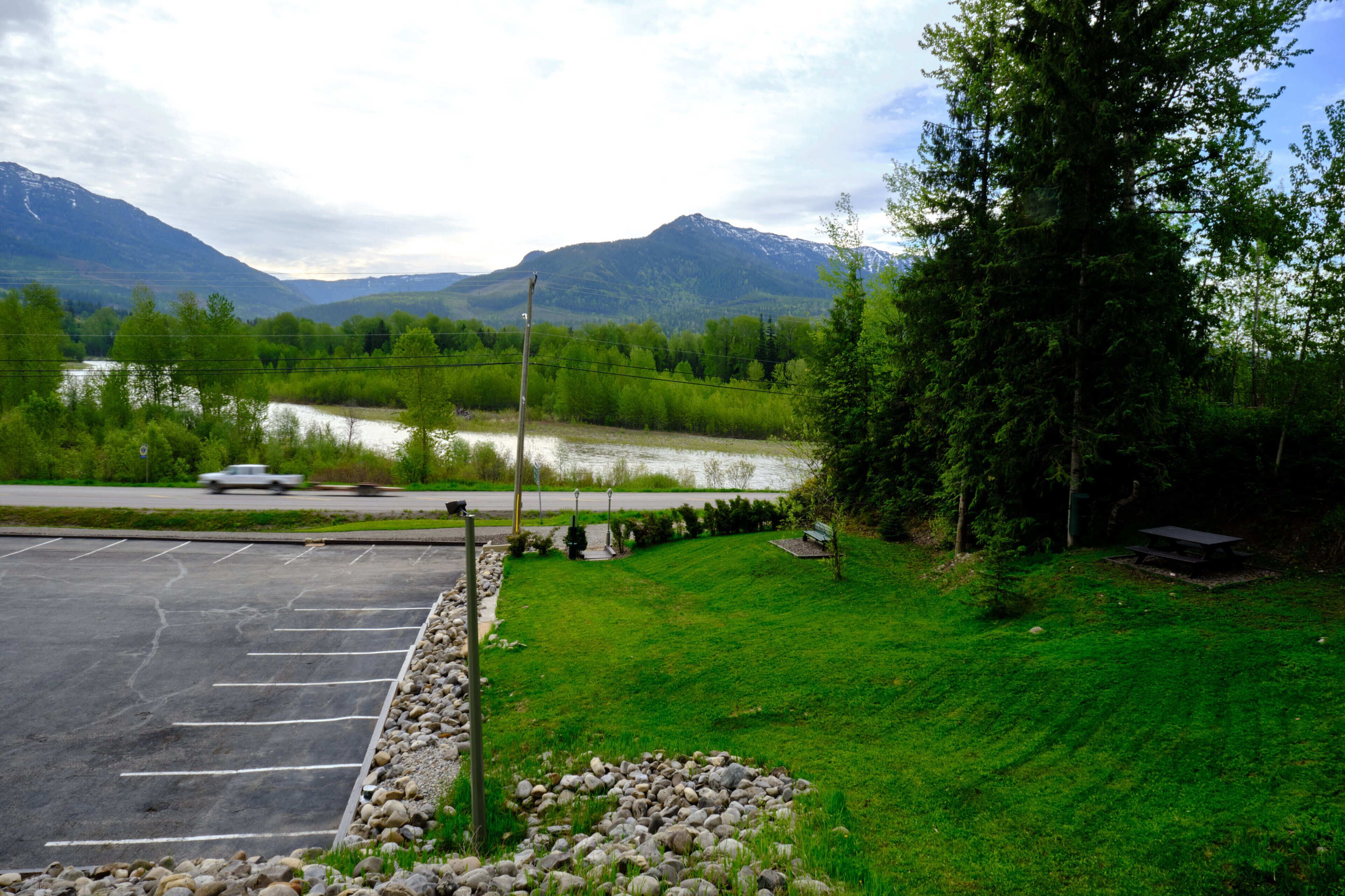 A parking lot with a river and mountains in the background.