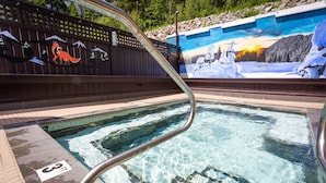 A swimming pool with a metal ladder, a mural with a wolf and a snowy landscape, and a '3FT' depth marker. - Fernie Fox Hotel (Fernie)