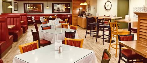 A restaurant with booths, tables, and a bar area.