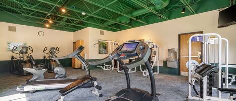 A gym with treadmills, elliptical machines, and weight equipment.
