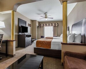 A hotel room with a bed, a desk, a television, a ceiling fan, and a window with curtains. - Comfort Suites Bakersfield (Bakersfield)