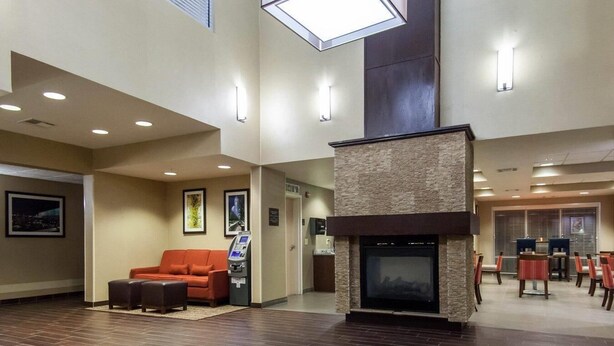 A spacious lobby with a fireplace, seating area, and a dining section.
