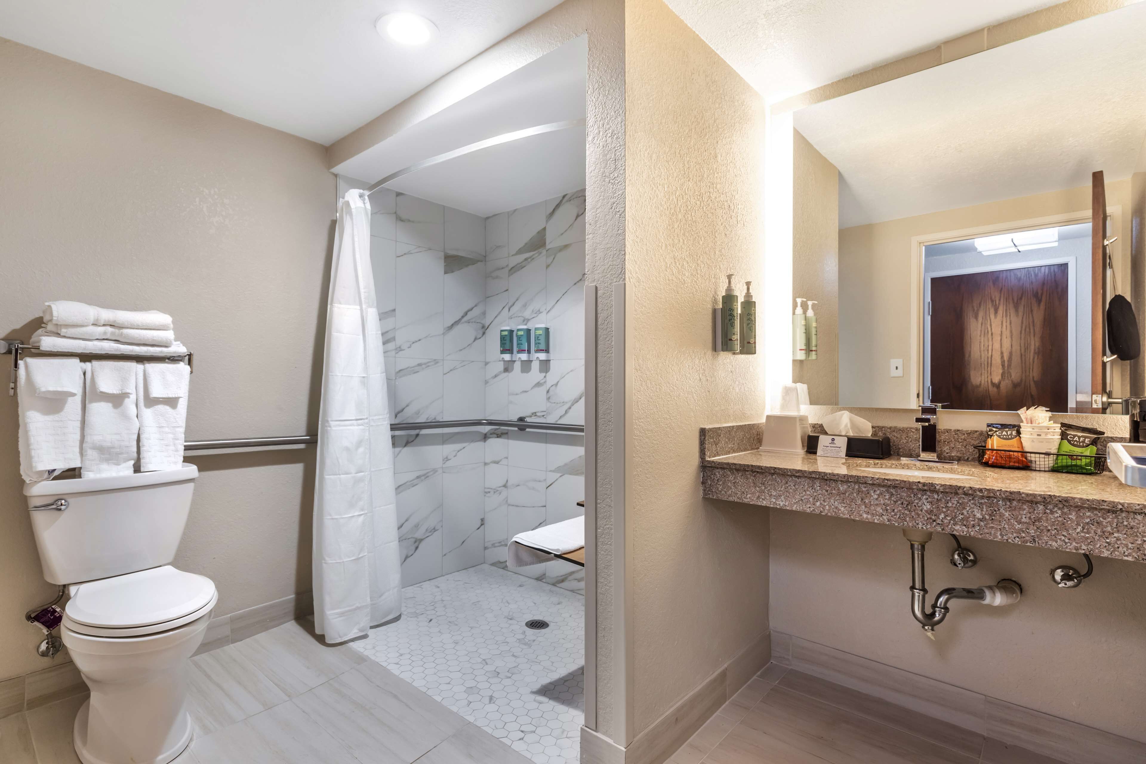 Un baño con inodoro, ducha y zona de lavamanos.