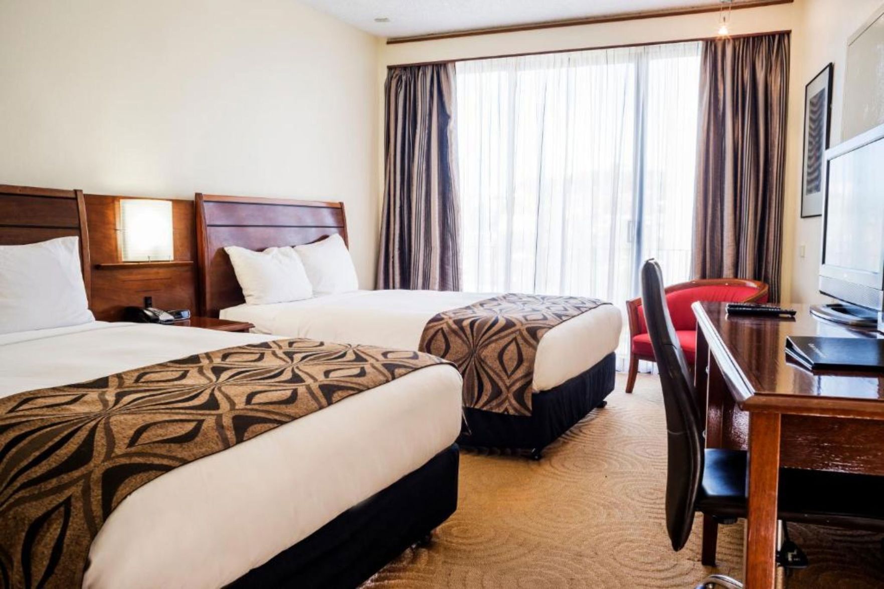 Ylelliset vuodevaatteet, tallelokero huoneessa, silitysrauta/-lauta