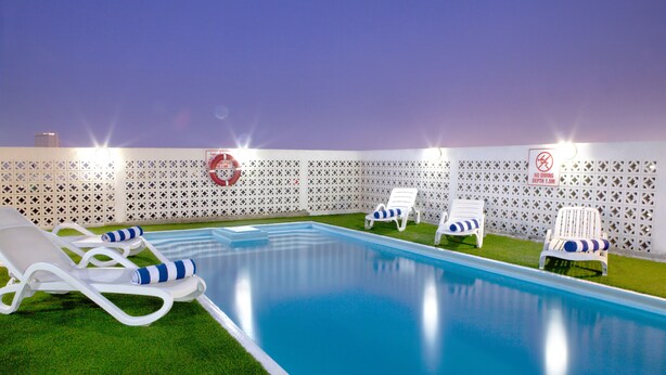A swimming pool with white lounge chairs and a no diving sign. - Landmark Hotel (Dubai)