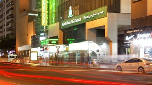 A hotel with a prominent sign for the White Fort Hotel, a landmark, and a bank branch. - Landmark Hotel (Dubai)