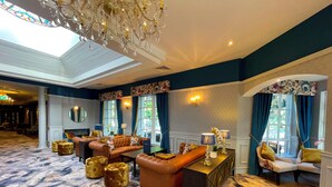 A spacious lobby with a high ceiling, a chandelier, and a patterned carpet. - Ardboyne Hotel (Navan)