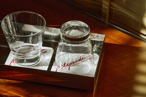Two glasses and a salt shaker on a tray with a logo.