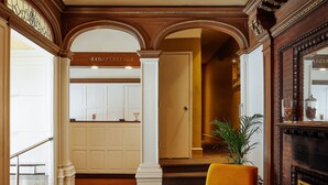 Un hall d’entrée avec un comptoir d’accueil, un escalier et une cheminée.