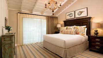 A bedroom with a large bed, a chandelier, a dresser, and a nightstand.