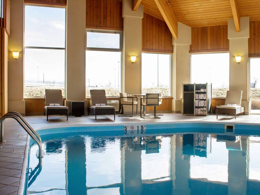 Una piscina techada, sillones reclinables de piscina