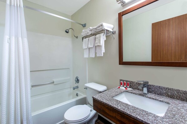 A modern bathroom with a bathtub, toilet, and sink.
