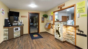 A reception area with a coffee machine, a microwave, a welcome mat, and a Wyoming sign.