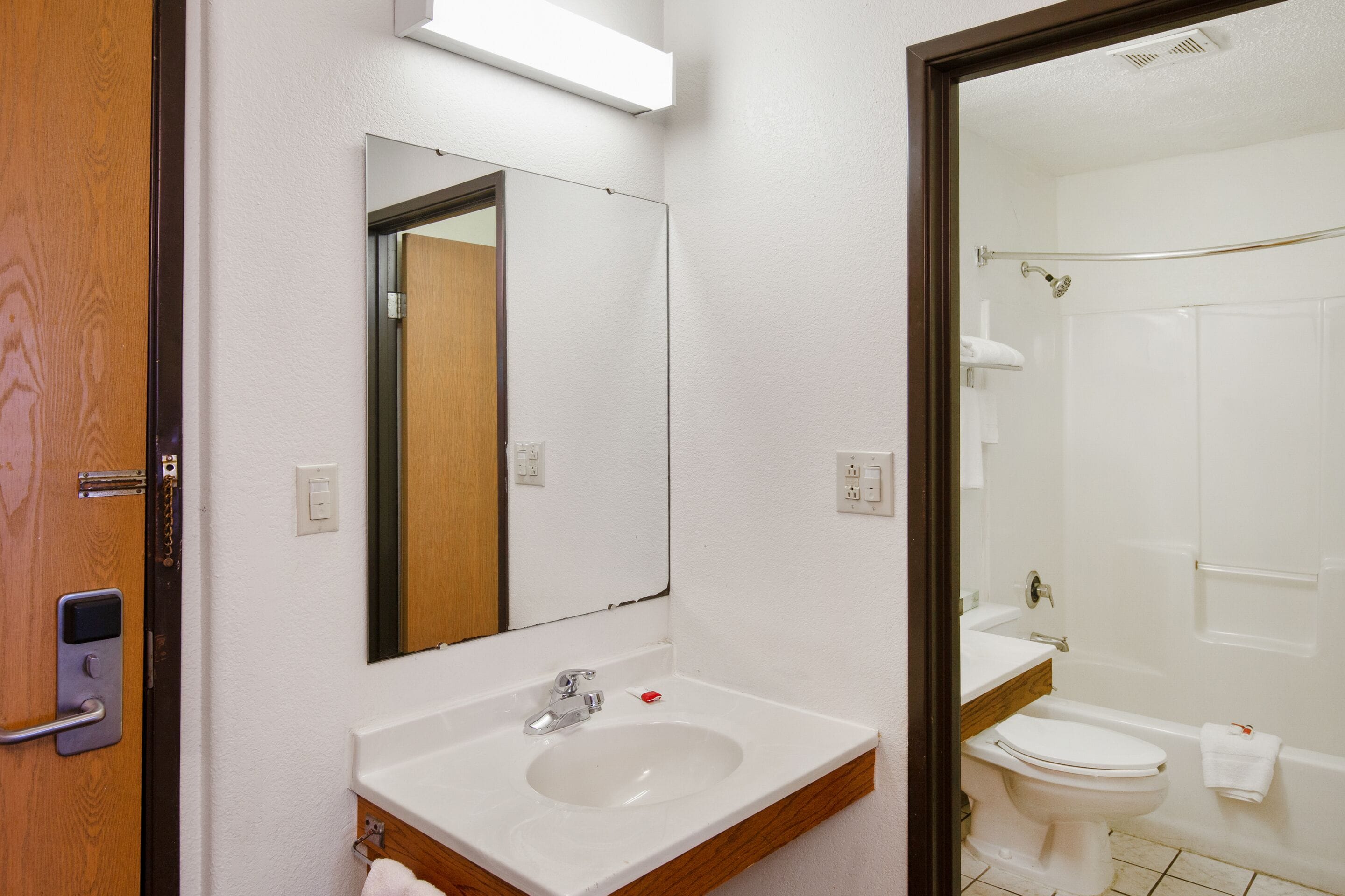 A bathroom with a sink, mirror, and toilet.