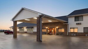 A hotel with a covered entrance, a car parked outside, and a brick facade. - Super 8 by Wyndham Bethany MO (Bethany)