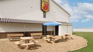A Super 8 motel with picnic tables and benches outside. - Super 8 by Wyndham Bethany MO (Bethany)