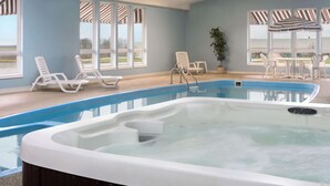 A swimming pool with lounge chairs and a hot tub. - Super 8 by Wyndham Bethany MO (Bethany)