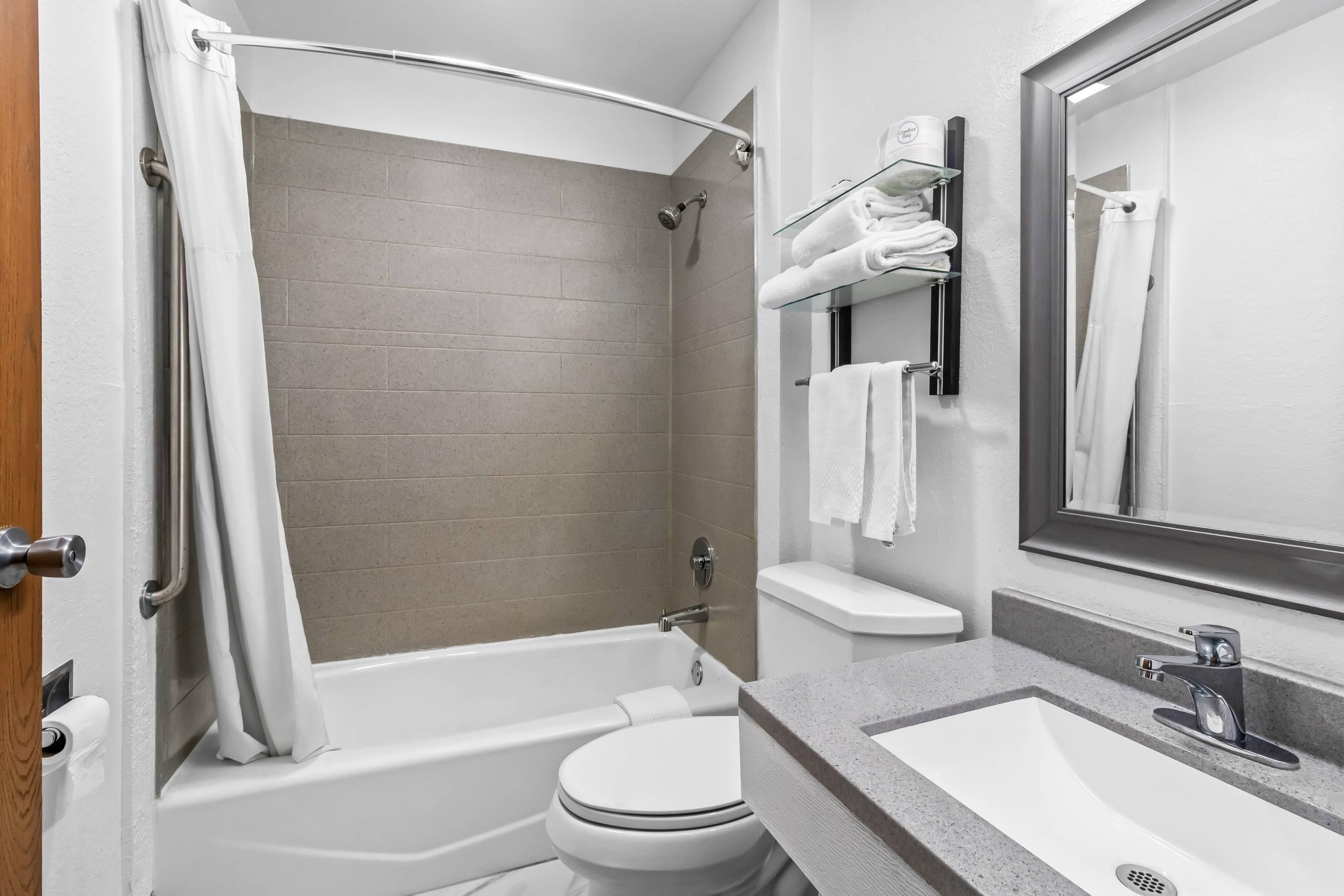 A modern bathroom with a bathtub, toilet, and sink.