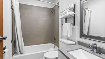 A modern bathroom with a bathtub, toilet, and sink.