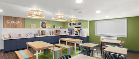 Una cocina moderna con pared verde, armarios de madera y una pizarra.