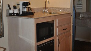 A compact kitchenette with a coffee maker, sink, and microwave. - Executive Inn and Suites (Sacramento)