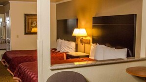 A hotel room with two beds, a chair, a table, and a mirror reflecting the room. - Executive Inn and Suites (Sacramento)