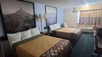 A hotel room with two beds, a desk, and a chair.
