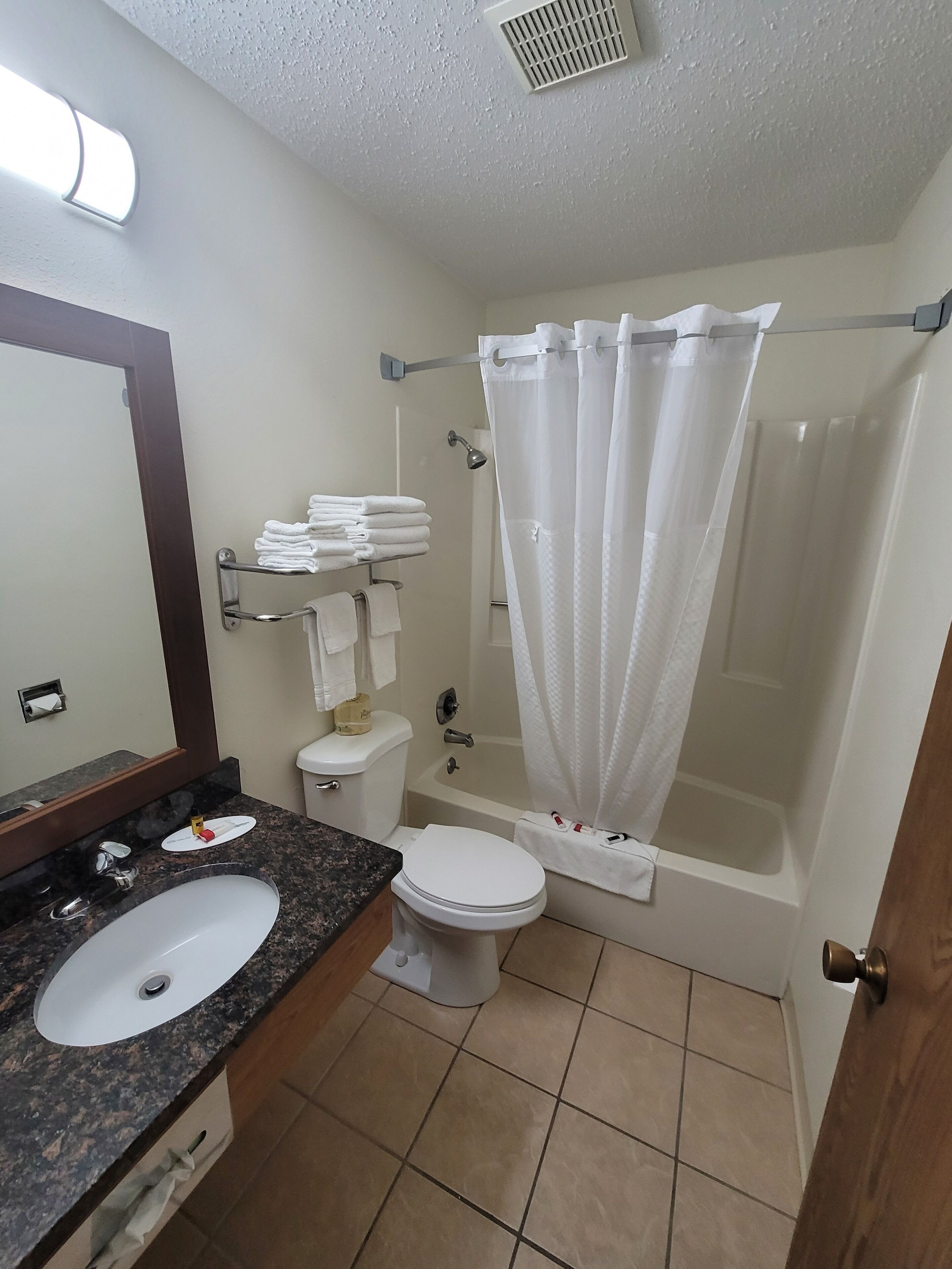 A bathroom with a sink, toilet, and shower area.