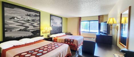 A hotel room with two beds, a desk, a chair, a TV, and a large painting on the wall.