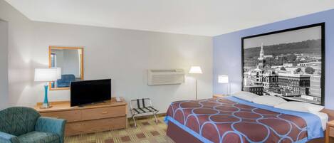 A hotel room with a bed, a television, a desk, and a chair.