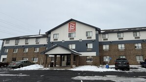 Ein Red Roof Inn mit Ziegel-Fassade, zahlreichen Fenstern und einem überdachten Eingang.