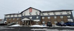 Um Red Roof Inn com fachada de tijolos, várias janelas e entrada coberta.
