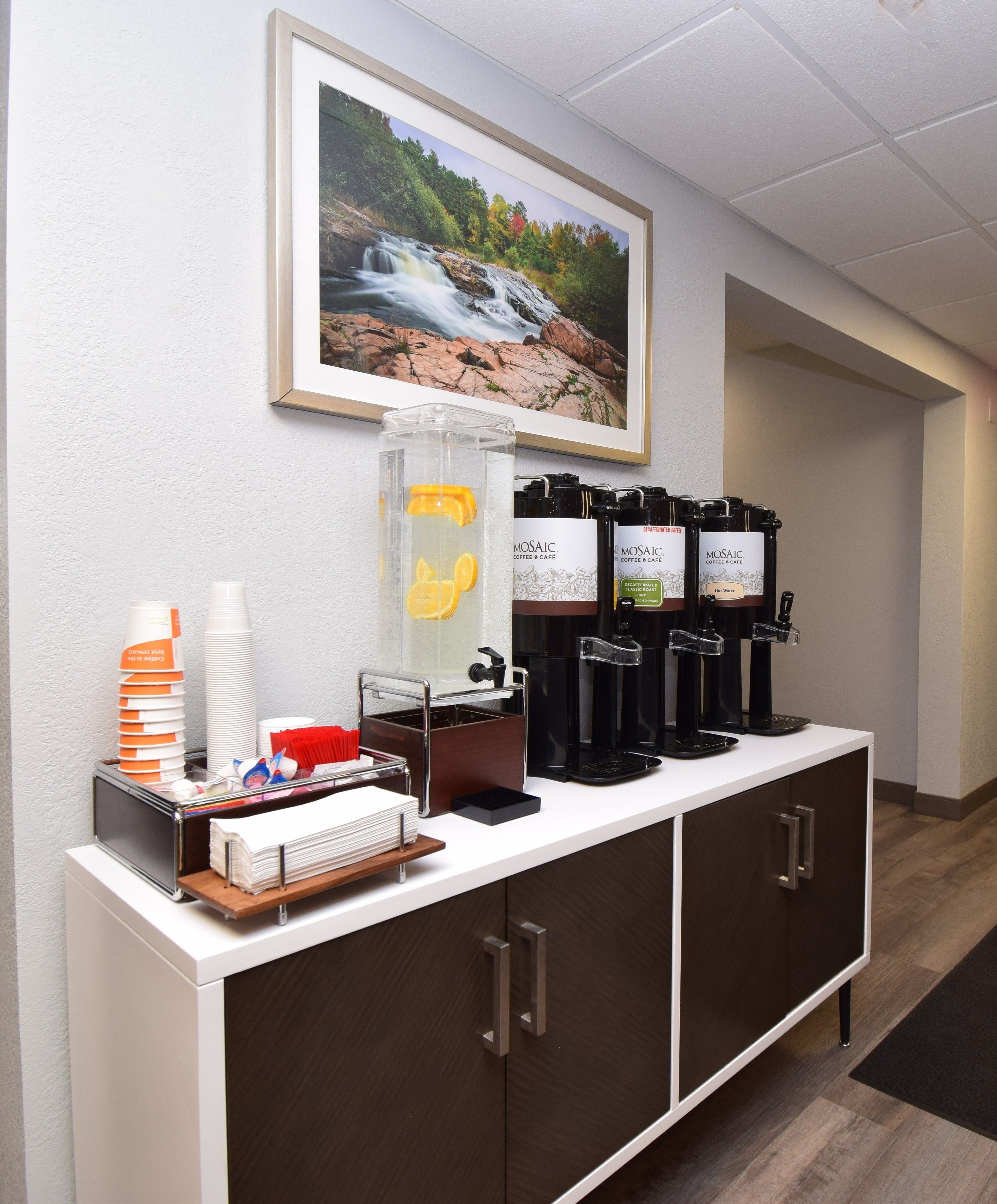 Ein Kaffee-Bereich mit Kaffeemaschine, Tassen und Wasserspender.