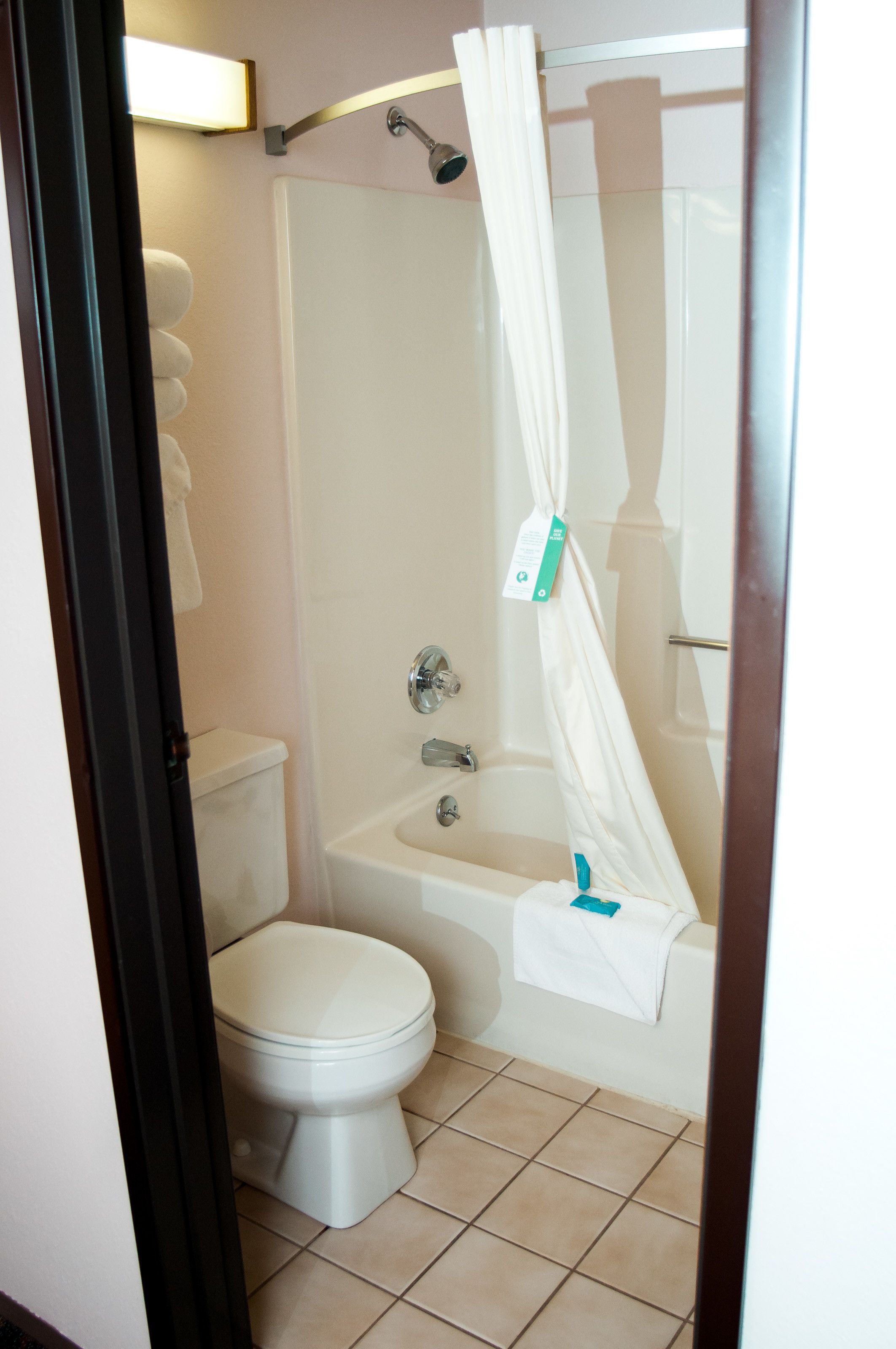 A bathroom with a toilet, a bathtub, and a shower curtain.