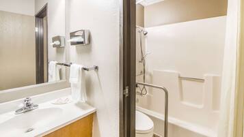 Een badkamer met een wastafel, spiegel, handdoekhouder, toilet en douche.