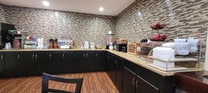 A kitchen with a stone backsplash, black cabinets, and a wooden countertop. - Super 8 by Wyndham Lebanon (Lebanon)
