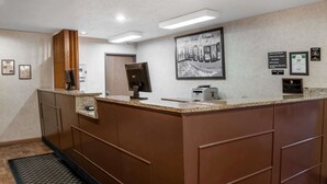 A reception area with a counter, computer, printer, and framed pictures on the wall. - Super 8 by Wyndham Lebanon (Lebanon)