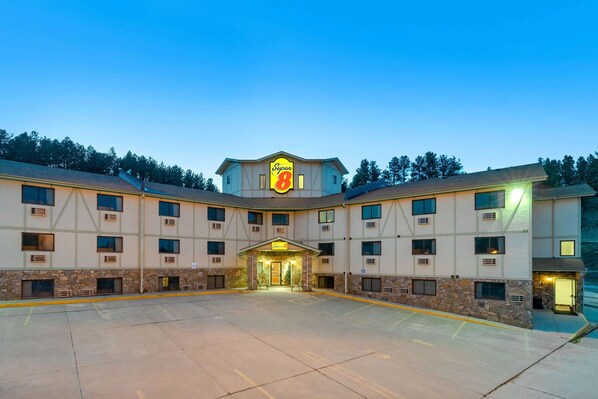 Ein Super 8 Hotel mit zentralem Eingang, mehreren Fenstern und einer Stein-Fassade.