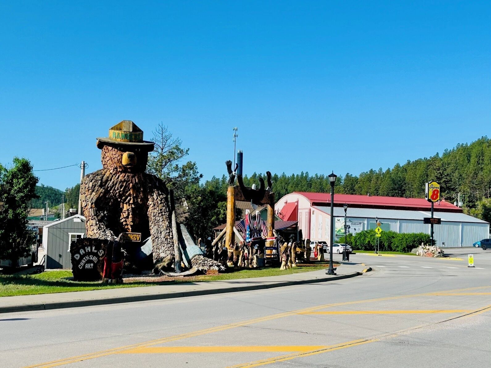 A large bear statue, a building with a red roof, and a sign for 'Sopas 8'.