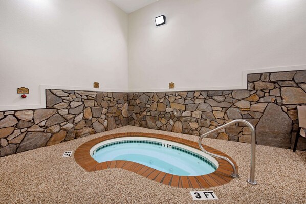 A hot tub with a stone wall backdrop, a metal ladder, and a 3 FT depth label.