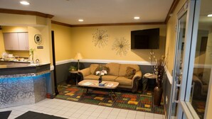 A living room with a sofa, coffee table, and decorative wall art.