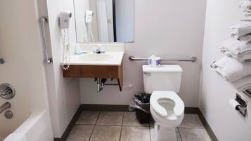 A compact bathroom with a white sink, mirror, and toilet.