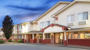 Een hotel met meerdere verdiepingen, een plat dak, grote ramen en een gevel van baksteen.