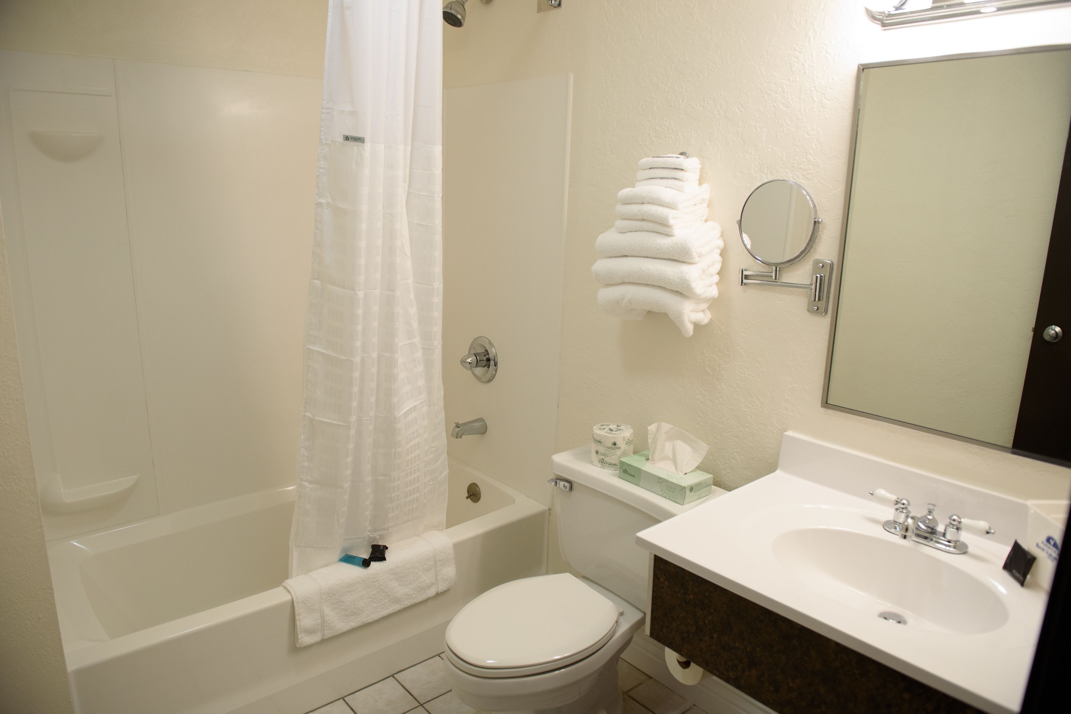 A bathroom with a bathtub, toilet, sink, and a mirror.