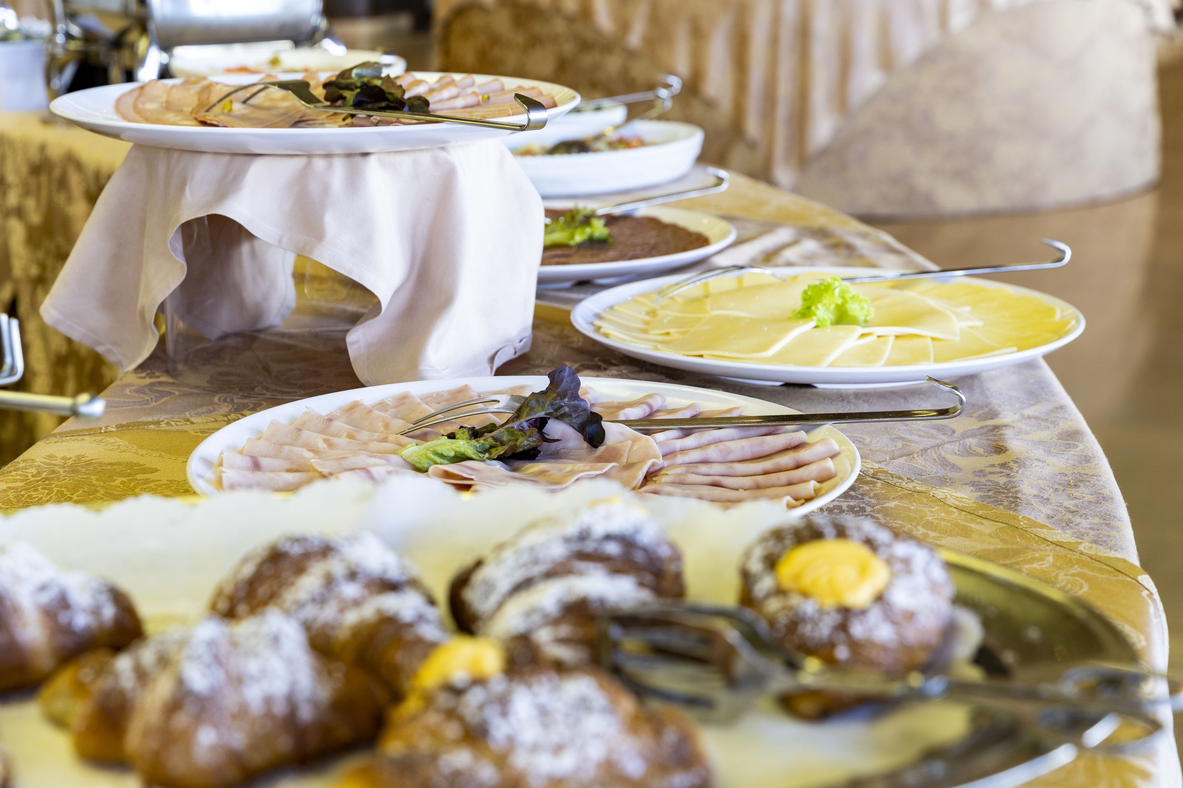 A buffet table with various dishes, including meats, salads, and desserts.