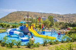 Una piscina al aire libre de temporada, sombrillas, tumbonas