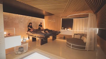 Una stanza spa con un lettino da massaggio, un piccolo angolo relax e una reception.